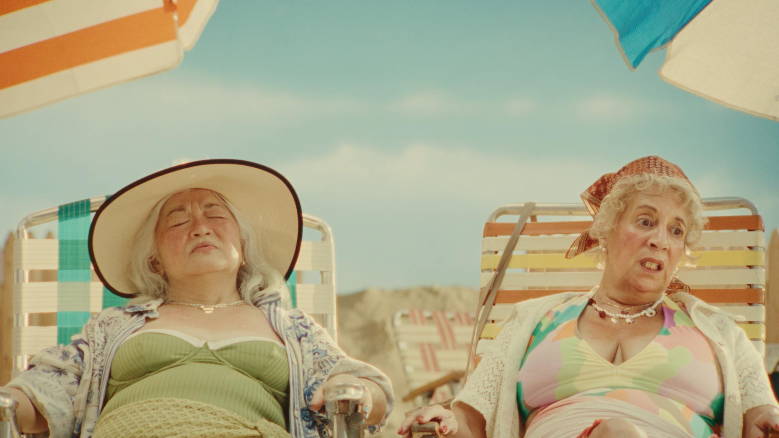 Two women relaxing on beach chairs in sunny setting, representing lifestyle storytelling and cinematic outdoor scenes in video production