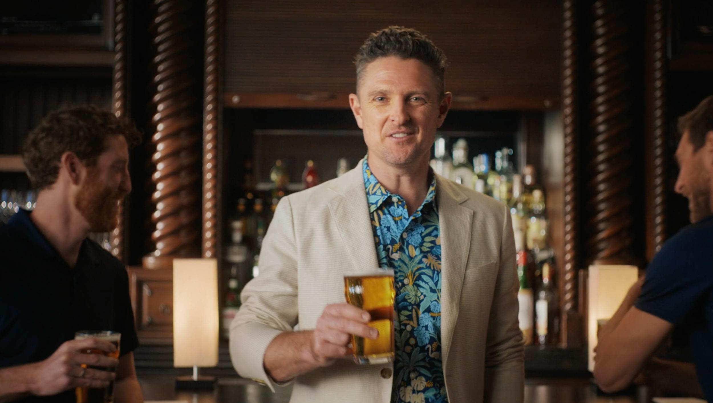 Man holding a drink in a bar setting, representing lifestyle storytelling and brand-focused video production by a creative agency
