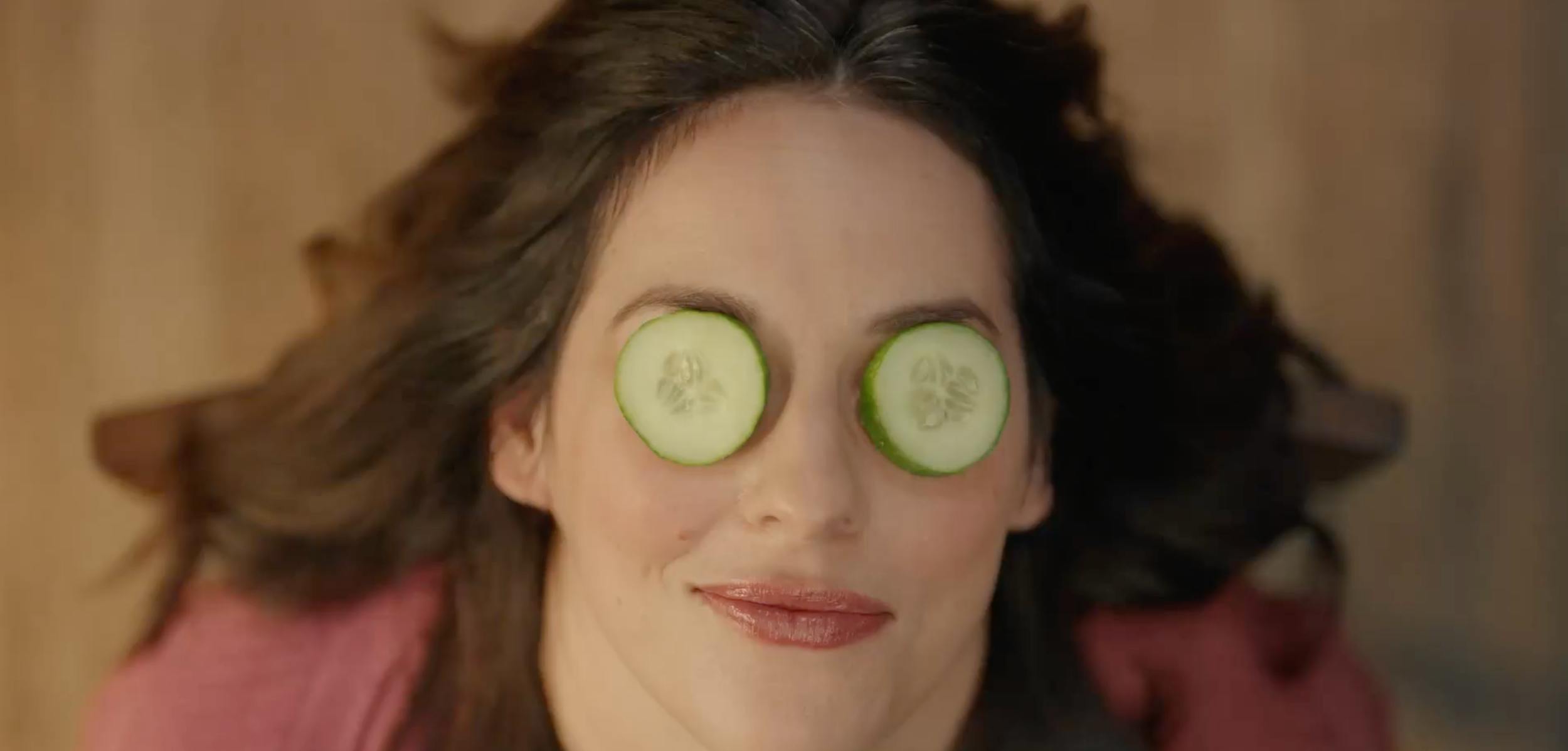 Woman relaxing with cucumber slices on her eyes, representing self-care, wellness, and lifestyle content.