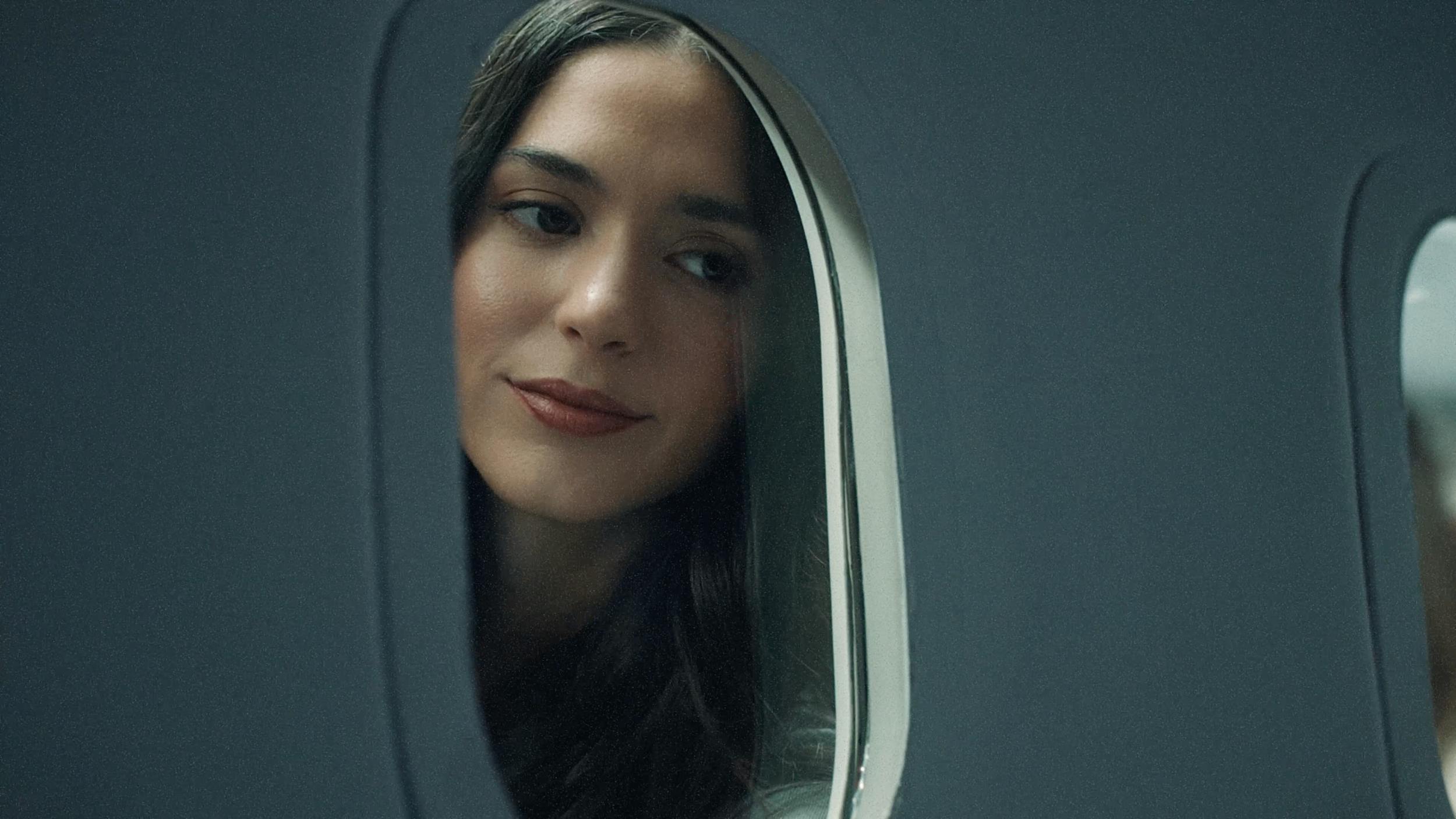 Woman looking out of an airplane window, capturing travel, reflection, and calm cinematic storytelling.