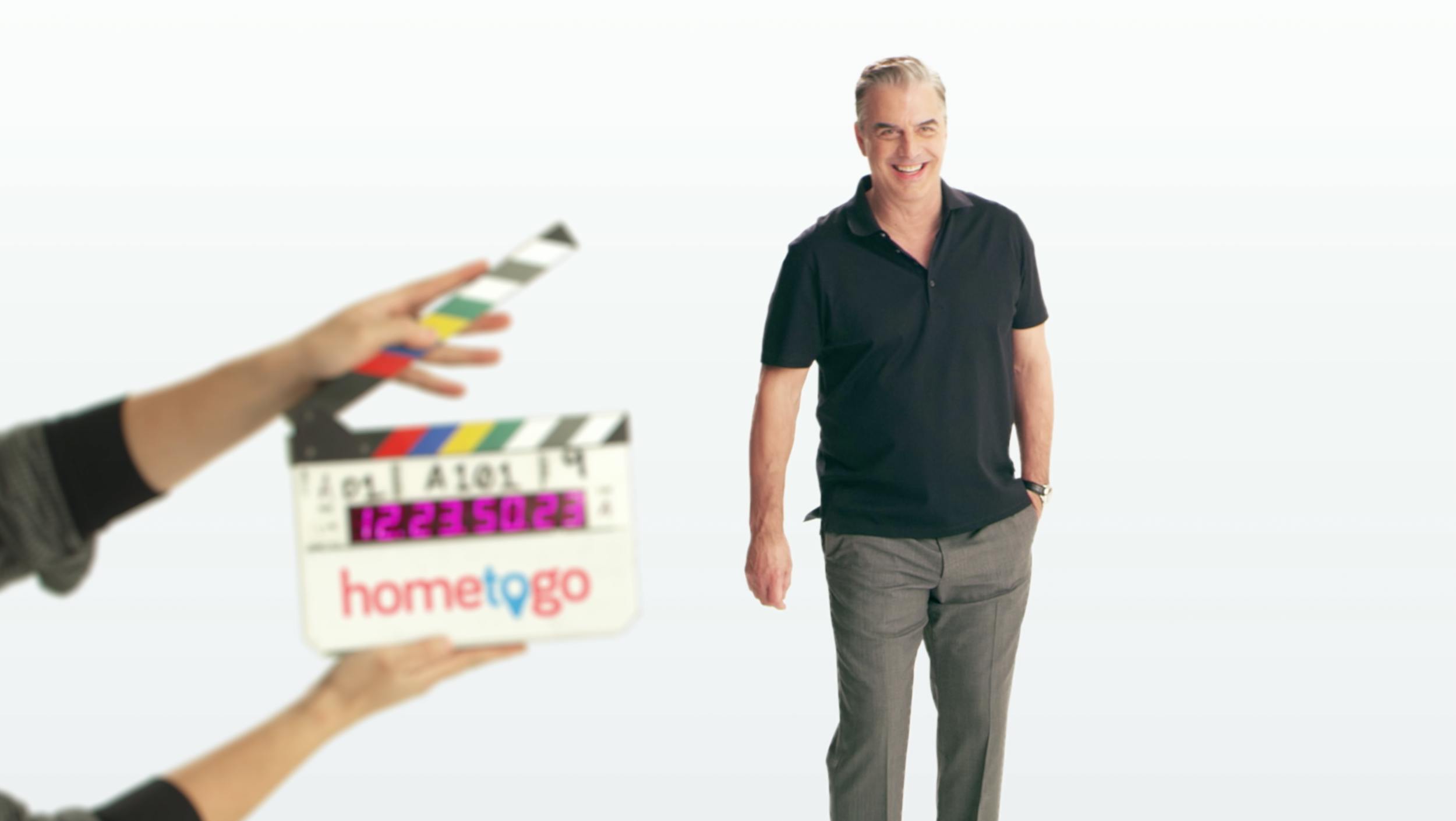 A man in a black shirt stands against a white background with colorful graphics on the left.