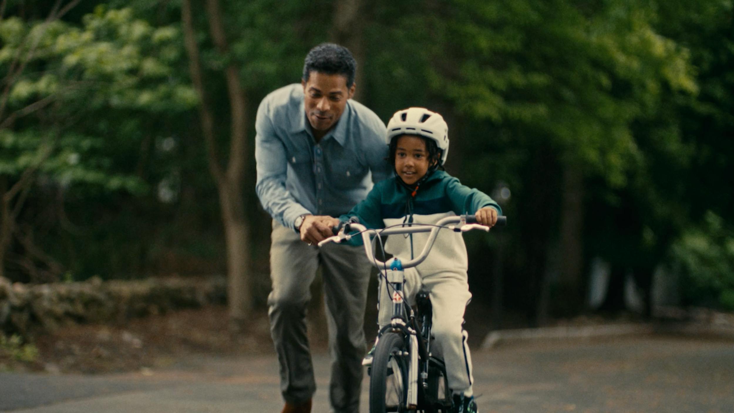 Father teaching a child to ride a bicycle, symbolizing family bonding, learning, and emotional storytelling moments.