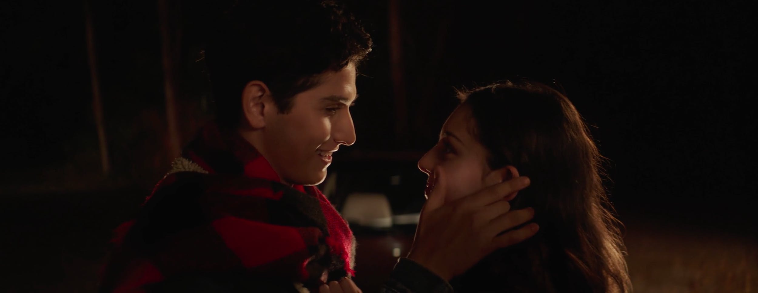 High-contrast cinematic night scene with low-key lighting focused on a young couple's face, utilizing natural ambient light to create a dramatic mood in film and video production.