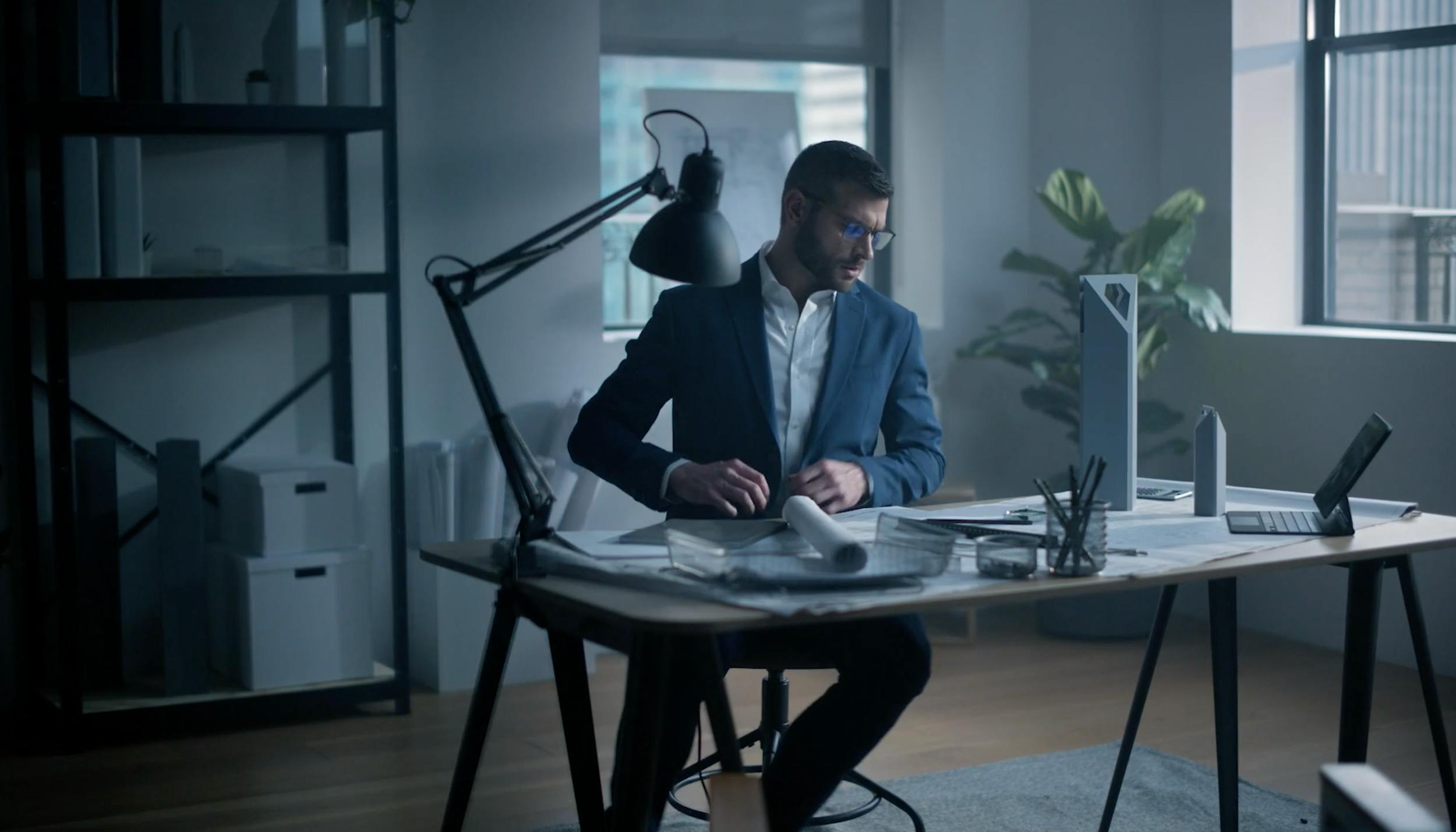 Professional post-production editor working at a modern studio desk.
