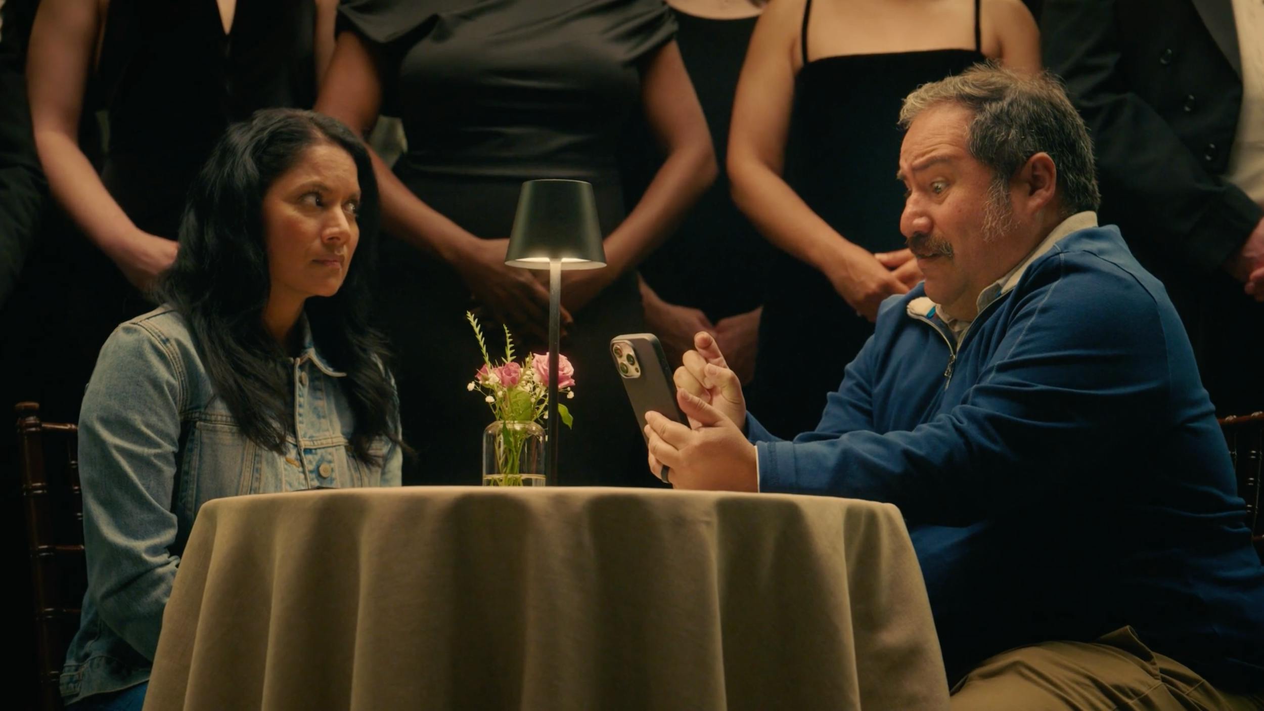 Man and woman seated at table in dramatic setting, representing character-driven storytelling and cinematic video production