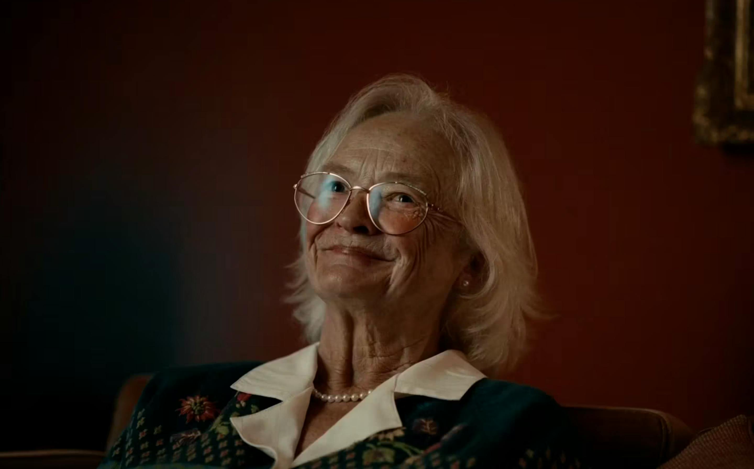 The thumbnail is a close-up, warm-toned portrait of an elderly woman smiling gracefully.