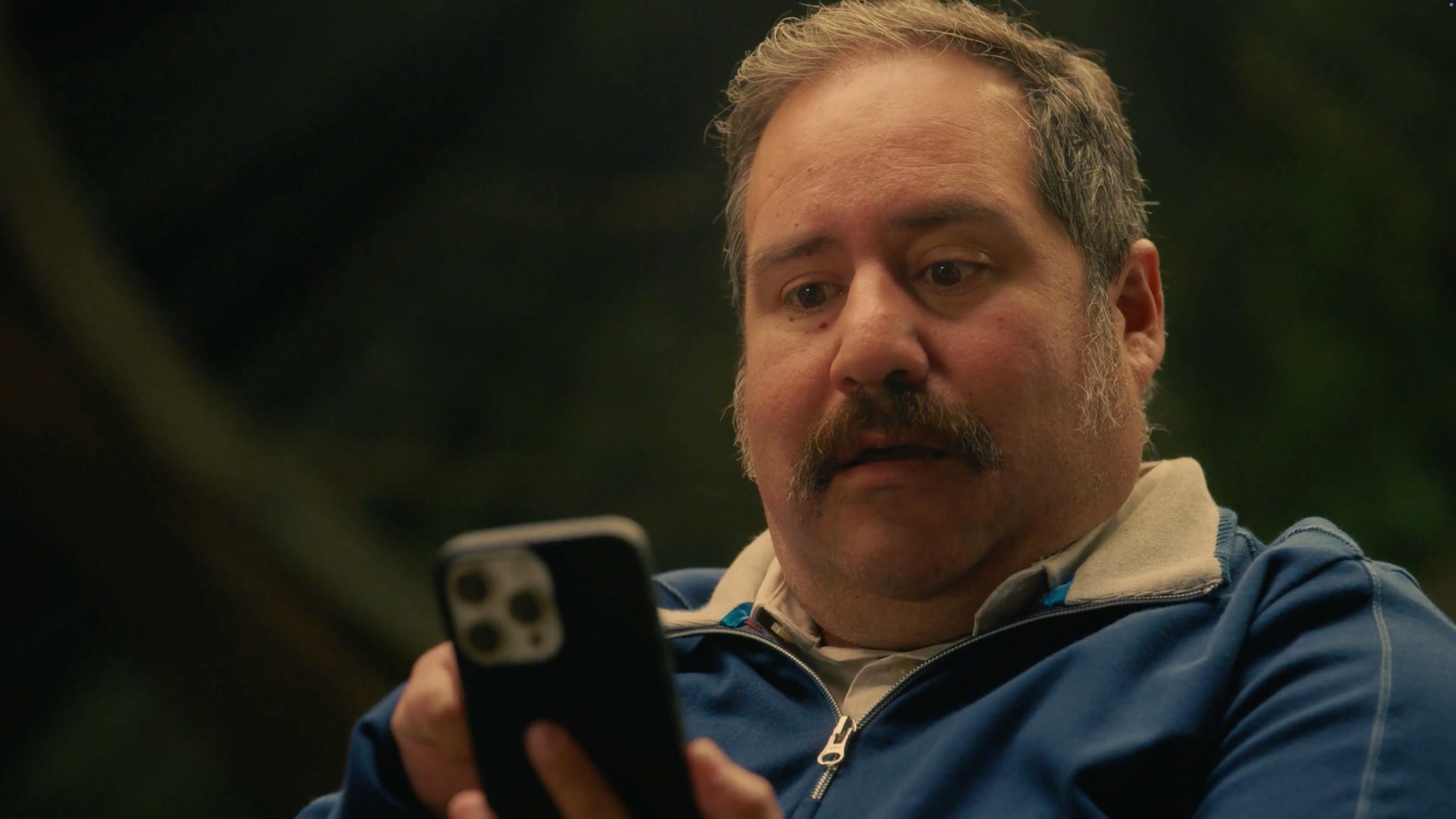 Man holding a smartphone in a dark outdoor setting, filmed by a live action film production company in Los Angeles for corporate video production and video marketing for businesses
