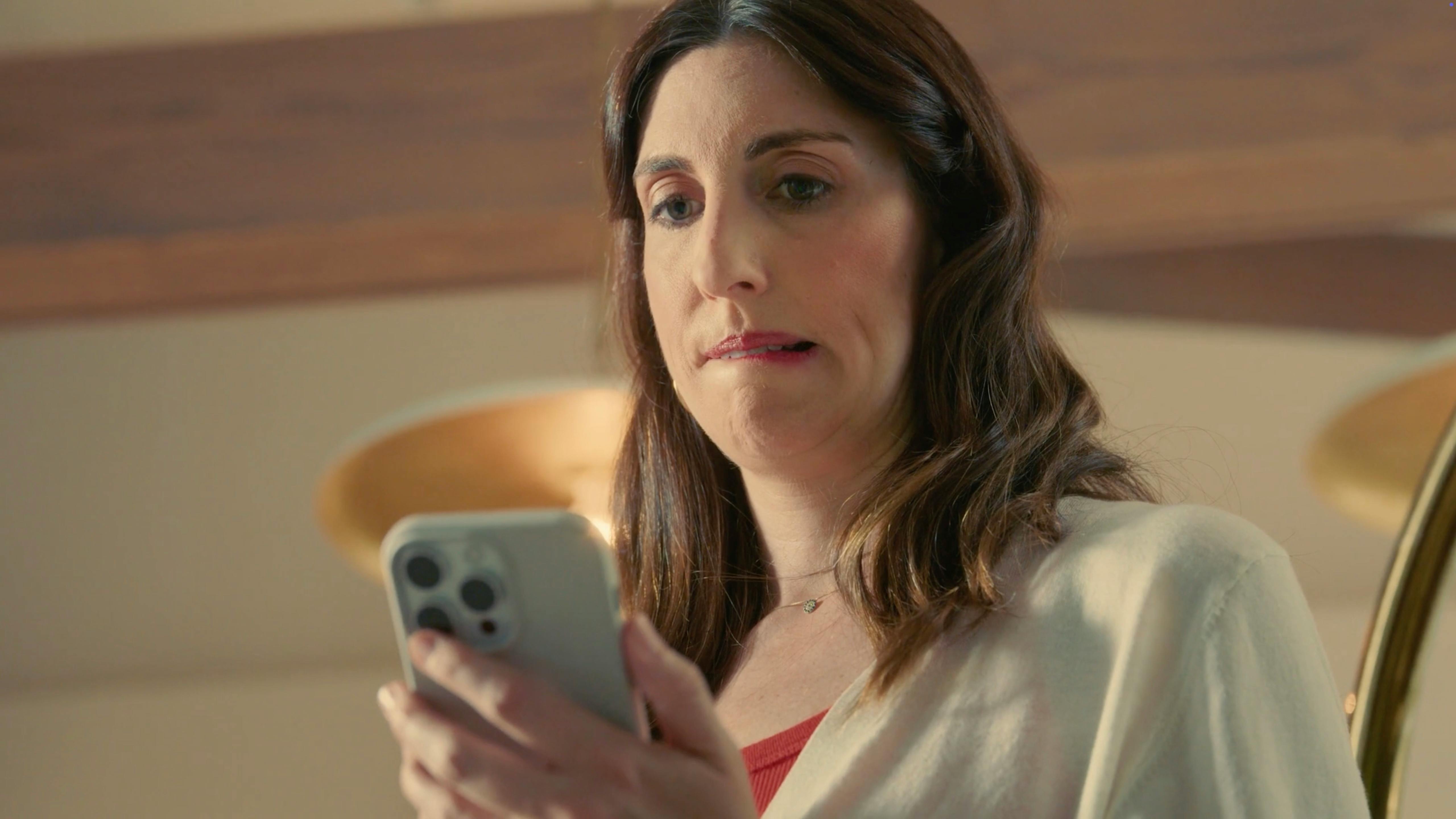 Woman looking surprised at her smartphone at home, created for a white label video production social media campaign for small businesses
