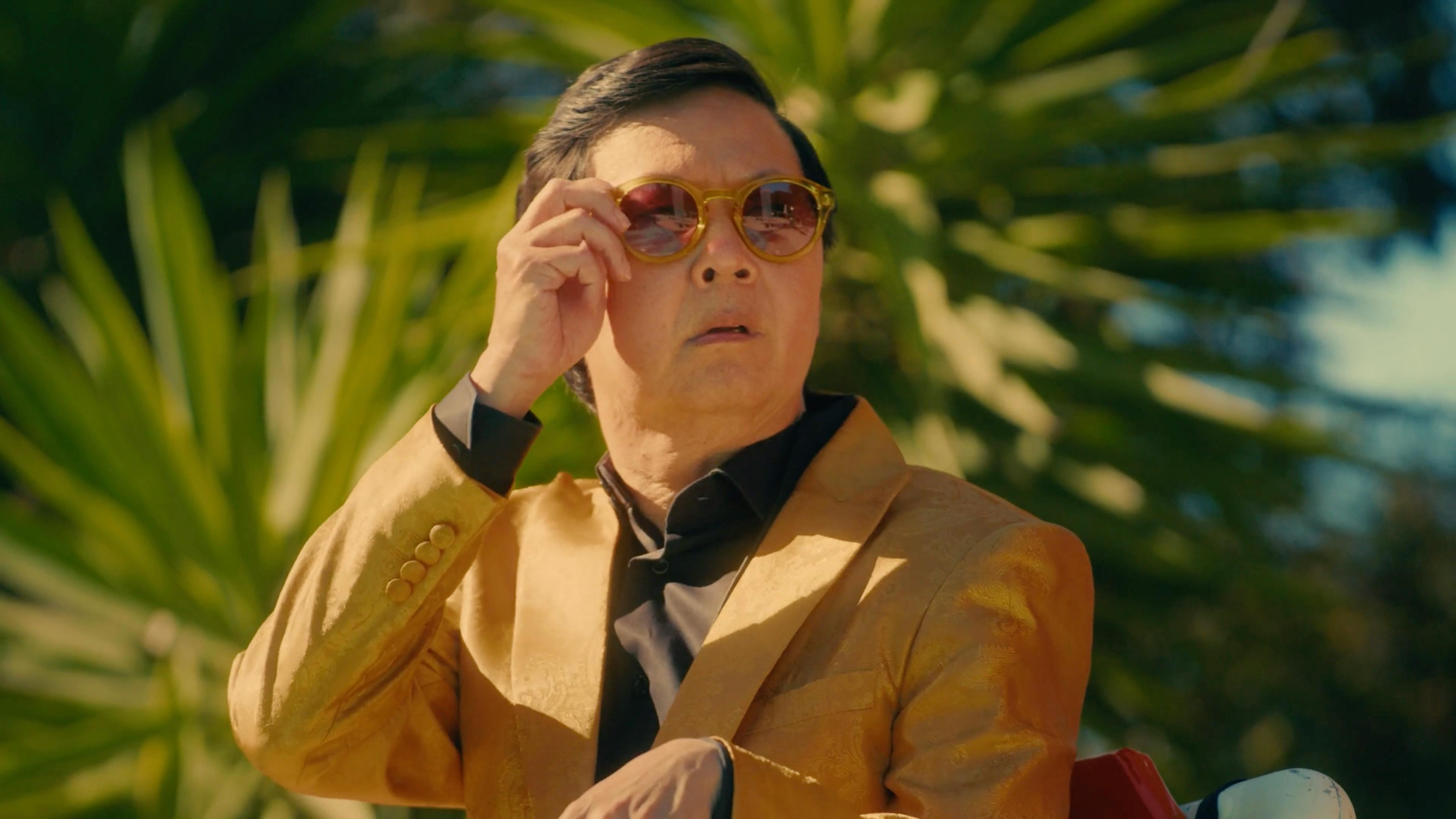 Ken Jeong in gold suit filming a celebrity endorsement with a video production company NYC.