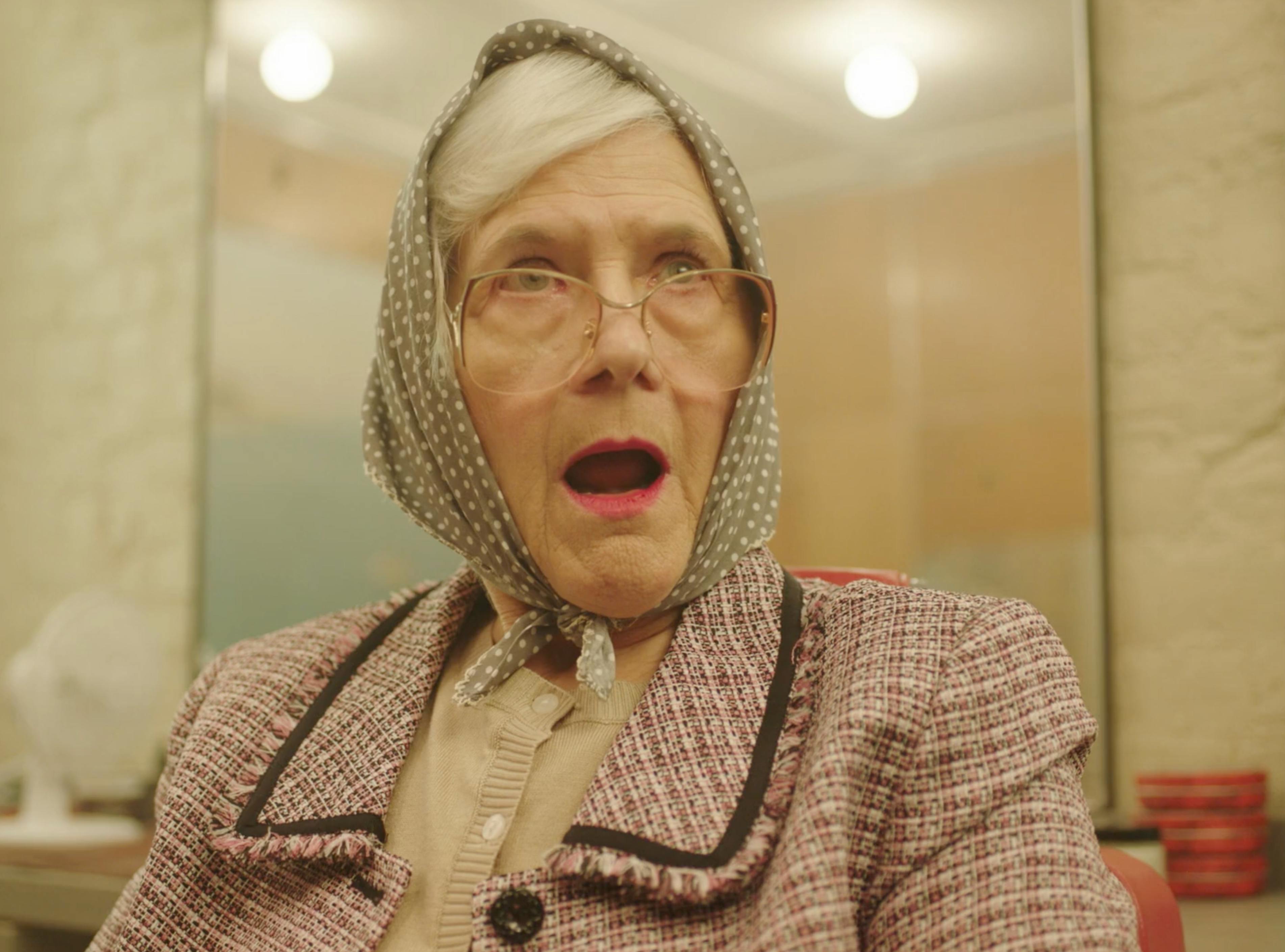 Older woman reacting in a close-up from the MICHAA Women’s Tales fashion film