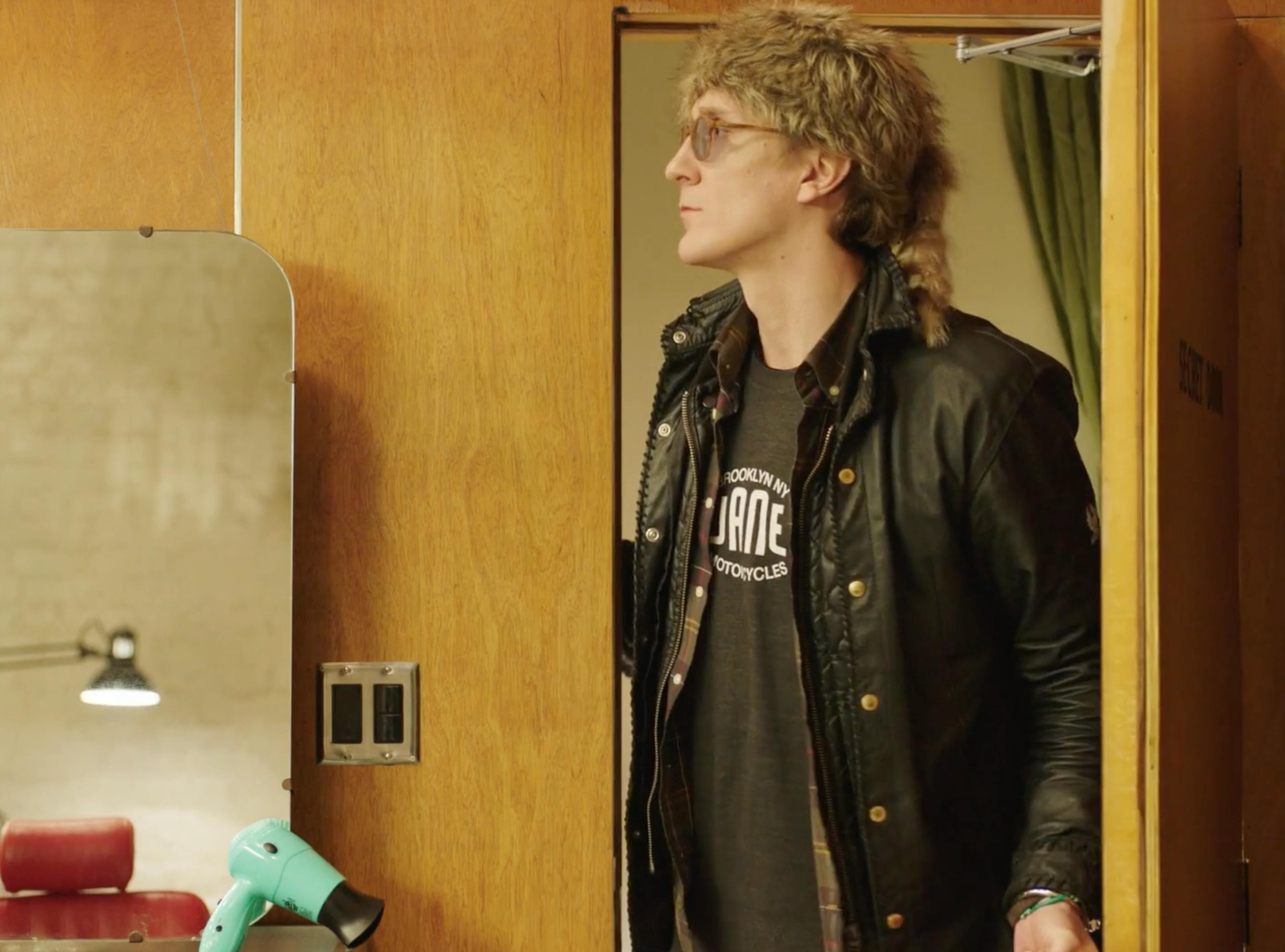 Male character in a New York hair salon scene from the MICHAA fashion brand film