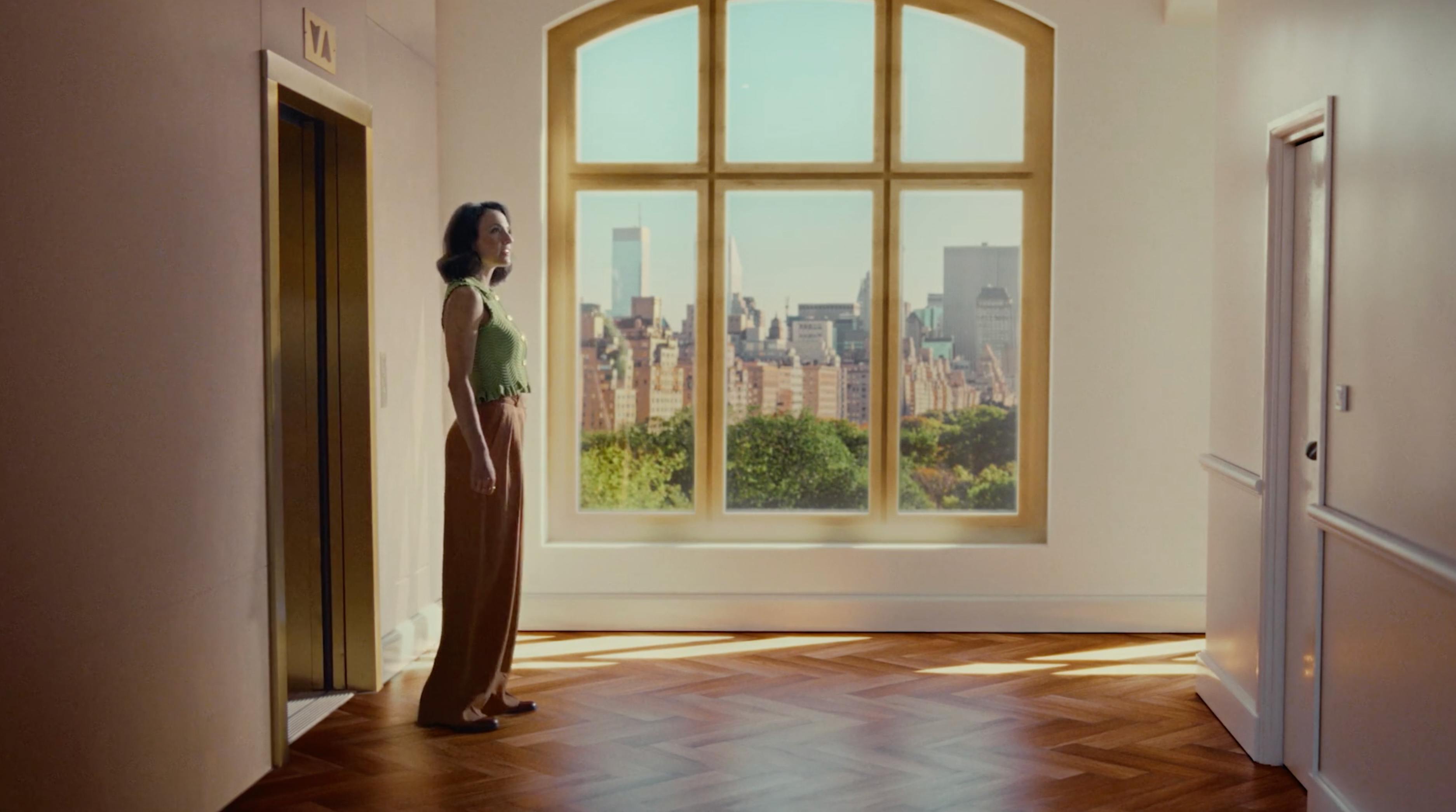 Woman standing in a bright hallway with city view from a real estate NYC video production service campaign