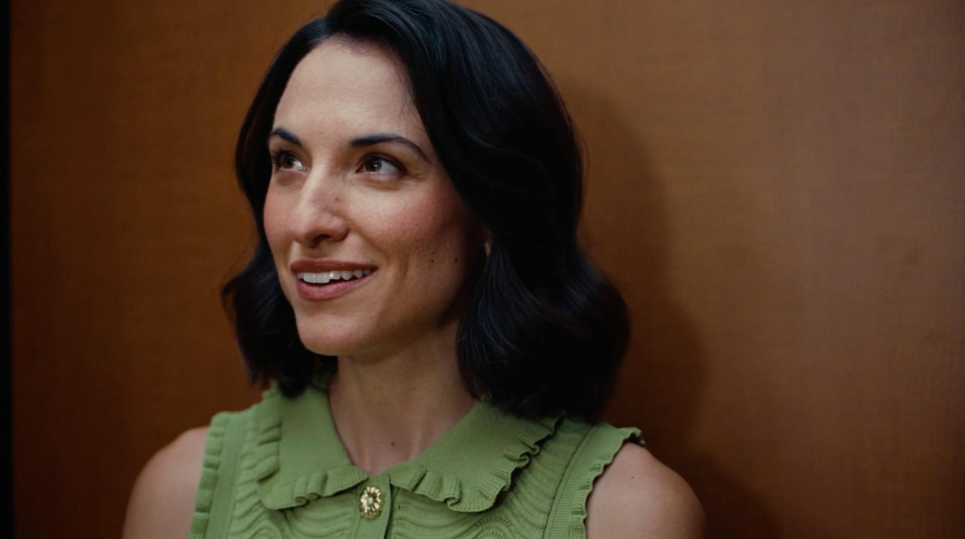 Smiling woman in a green dress from a cinematic real estate film series by a creative video agency