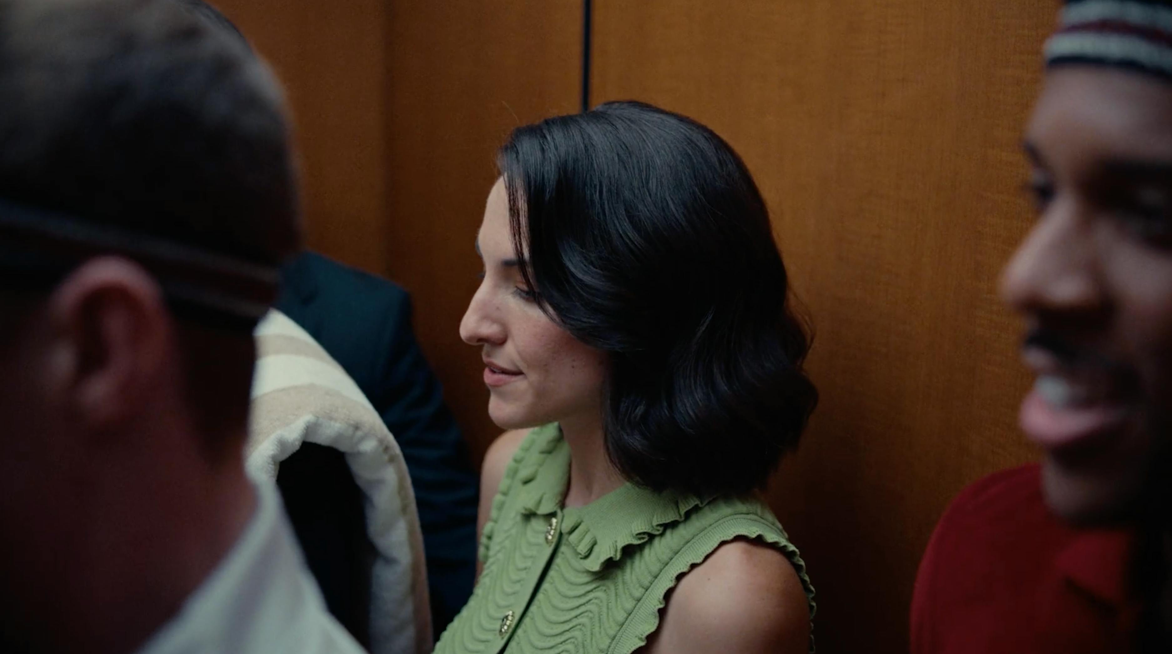 Woman in a green dress talking in an elevator during a premium real estate video production campaign