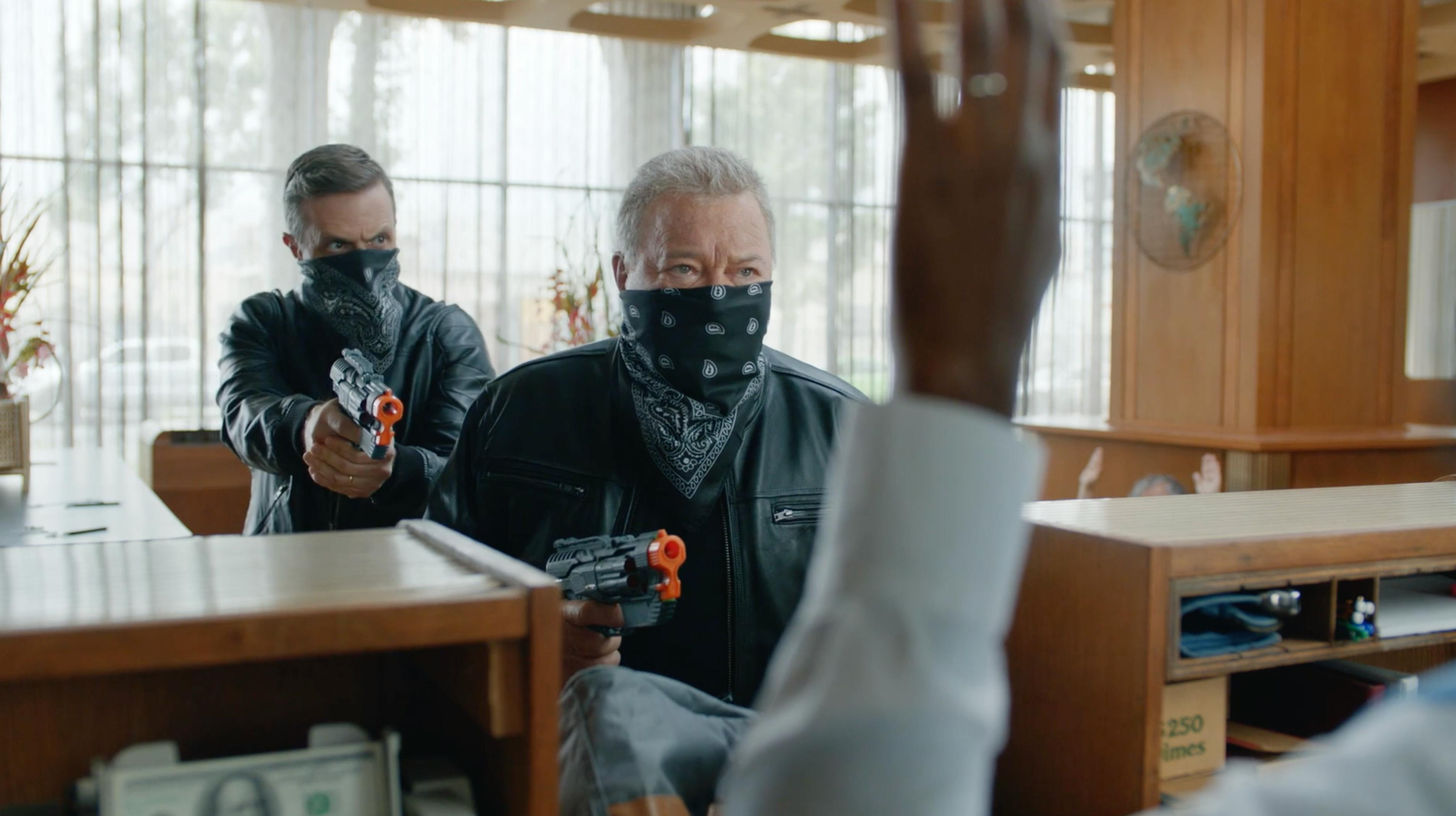 Masked man aiming a prop device across a counter in a branded episodic content video producer Los Angeles campaign