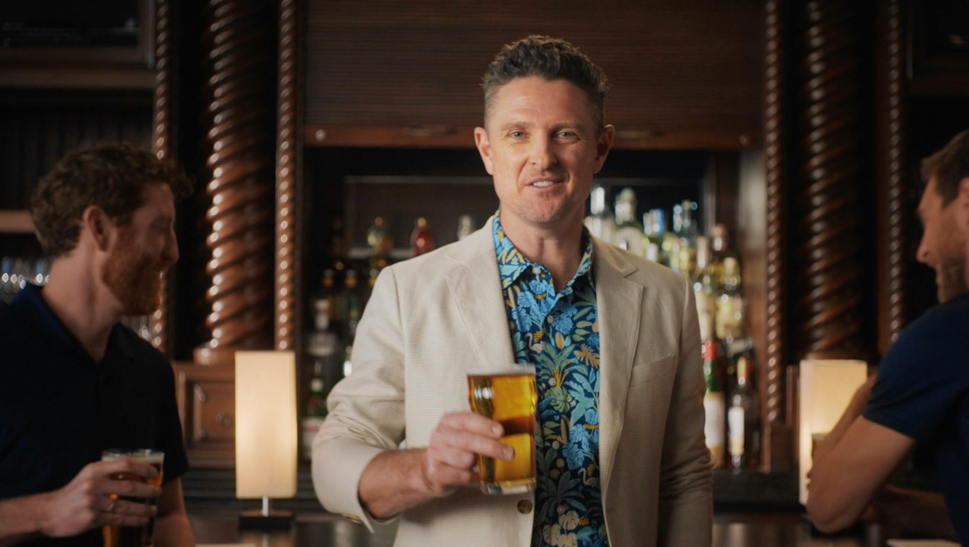 Man holding a drink in a clubhouse scene from a California sports video spot by a creative video agency
